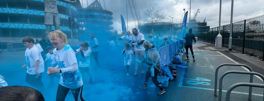 children running a colour run being covered in blue colour powder